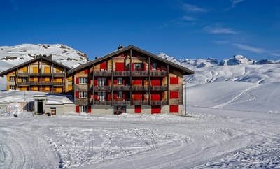 两个红色和黄色的房子包围在白天的雪原
